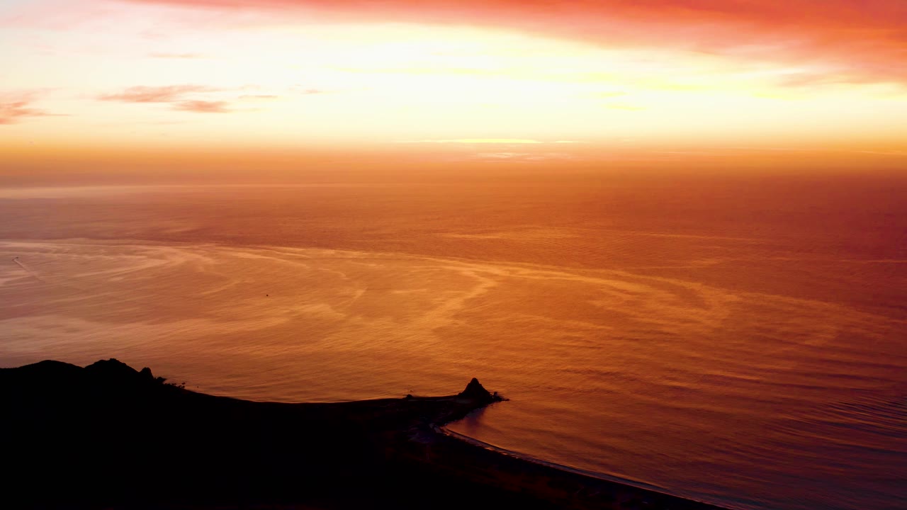 At 0:01, the bright horizon band sits above orange ocean texture and a black shoreline shape in Cabo Pulmo, with no visible people.
