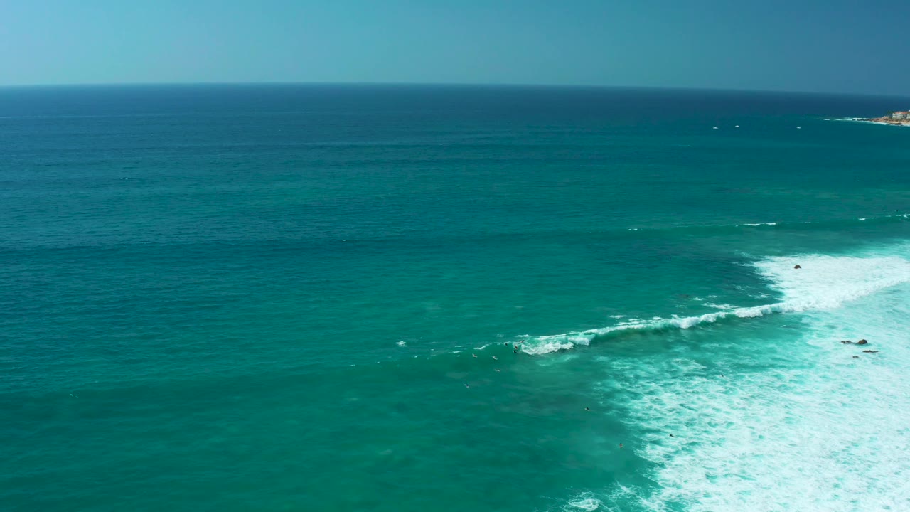 Aerial ocean frame from Marquis Los Cabos with the foam patch broader near the lower center and open turquoise water beyond, with no visible people.