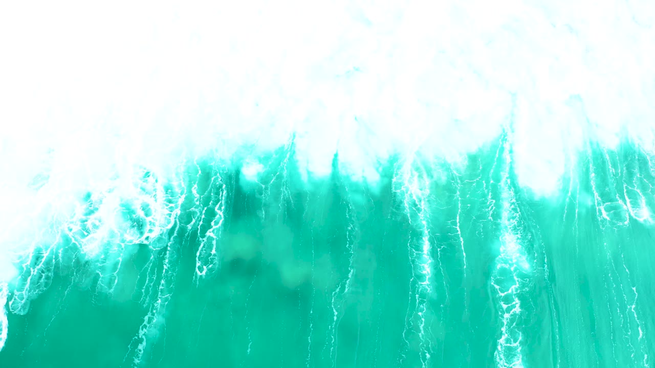 Aerial view at Marquis Los Cabos, Mexico, with a wide blown-white foam band pressing into clear turquoise water and no visible people.