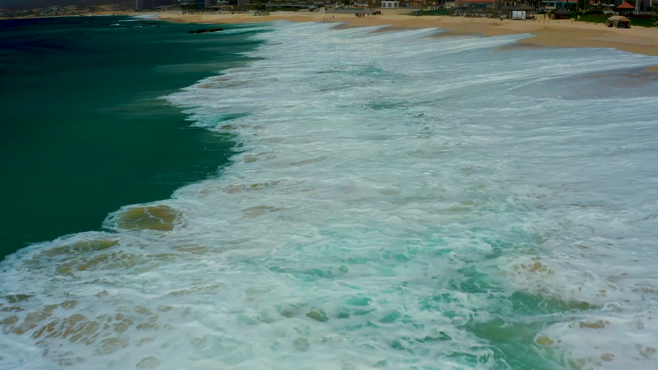Foamy waves covering shallow water near shore