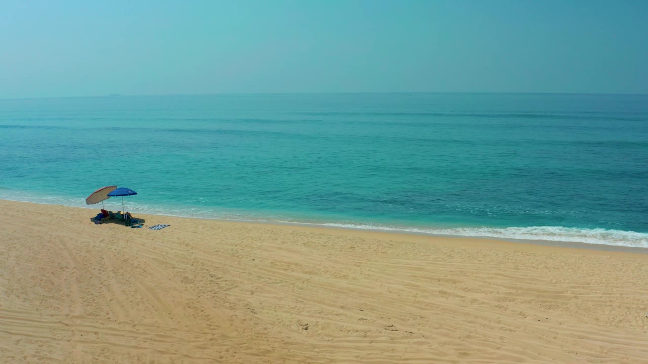 Aerial shoreline view with umbrella near the left edge