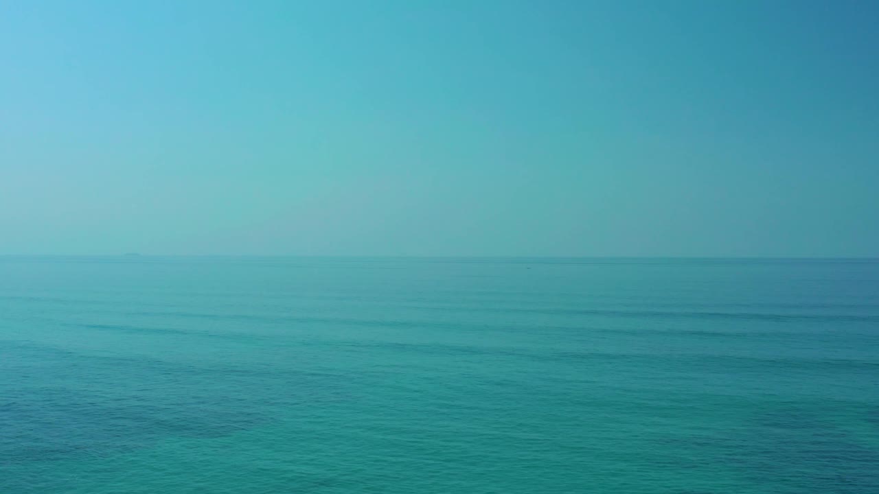 Turquoise ocean stretching to a straight horizon line.