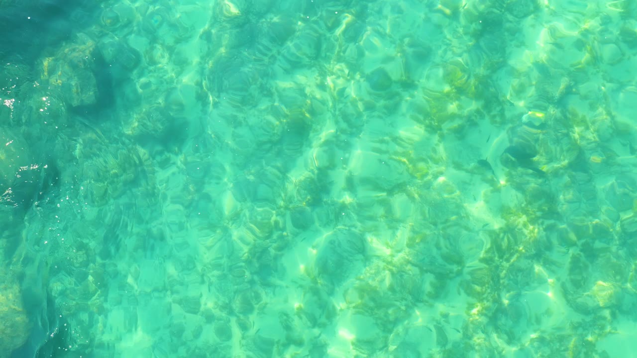 At Shipwrecks Los Cabos, shallow turquoise ocean water spreads across the frame with bright rippling light and no visible people or objects.