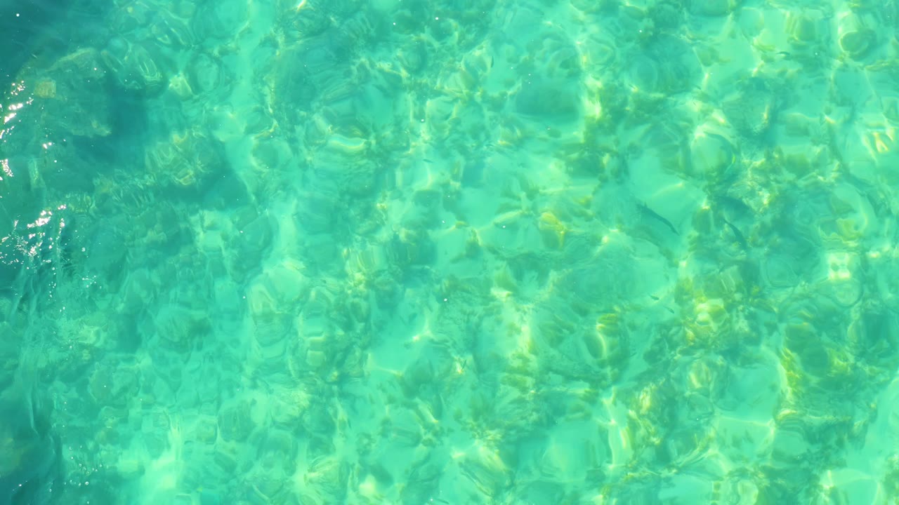Clear water over a visible bottom with small surface highlights