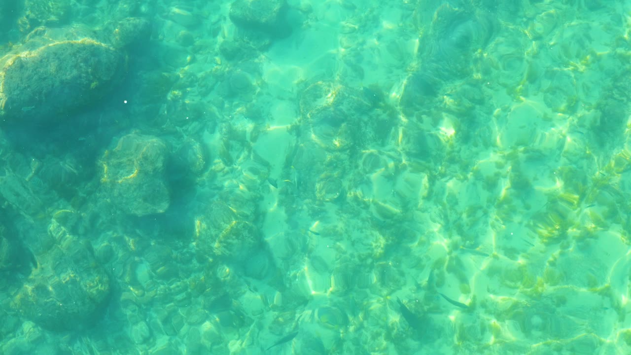 Clear turquoise water over submerged rocks
