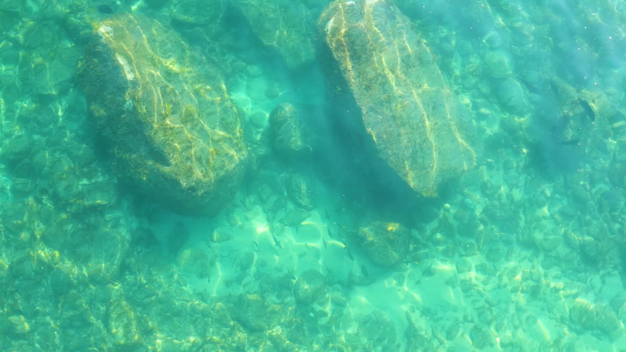 Clear turquoise water over submerged rocks