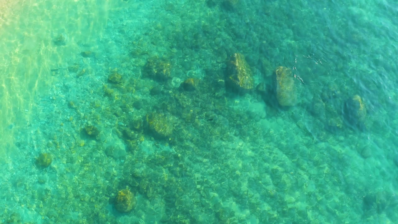 Clear green-blue water with submerged rocks