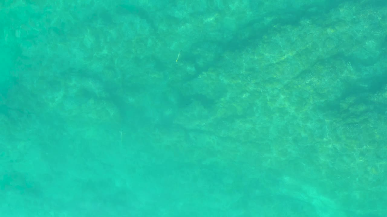 A second view of the shallow Shipwrecks Los Cabos water shows the rocky bottom slightly shifted under green-blue ripples, with no visible people.