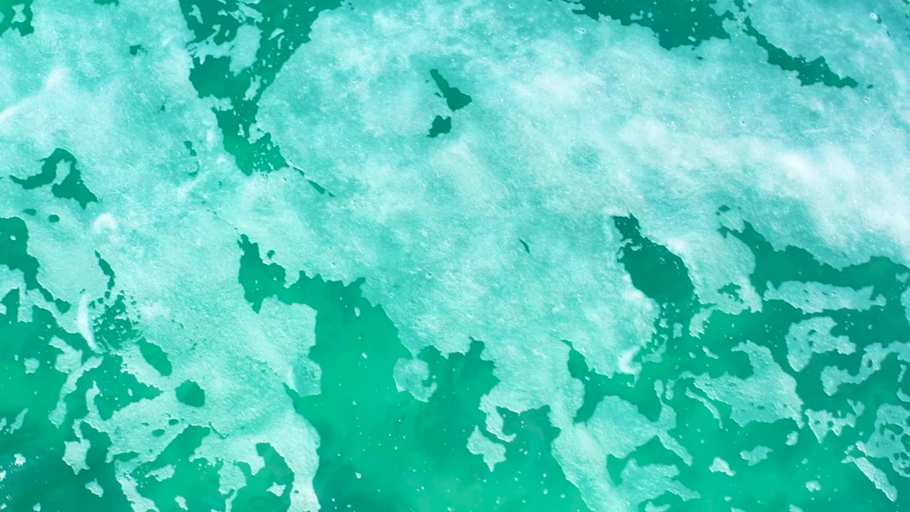At 0:01, white foam appears more spread across the upper part of the turquoise water surface at Marquis Los Cabos, with no visible people.