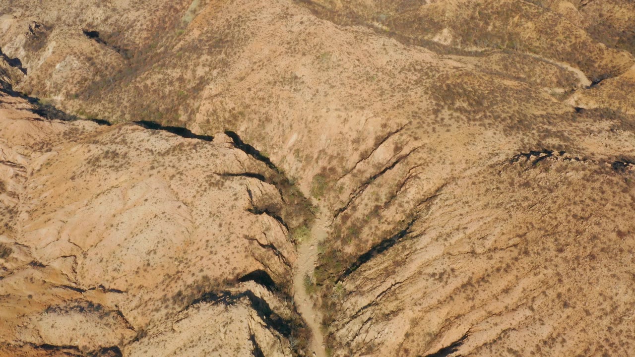 Dry wash between rounded desert ridges