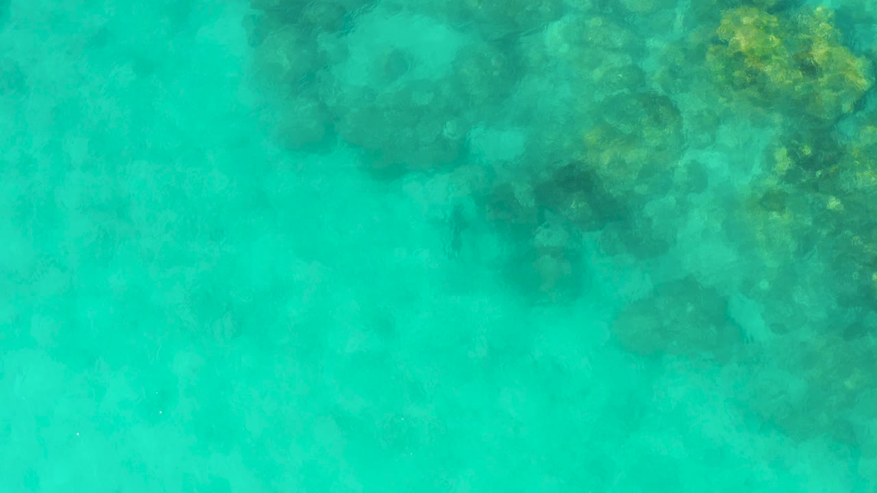 Turquoise water over submerged coral and rocks