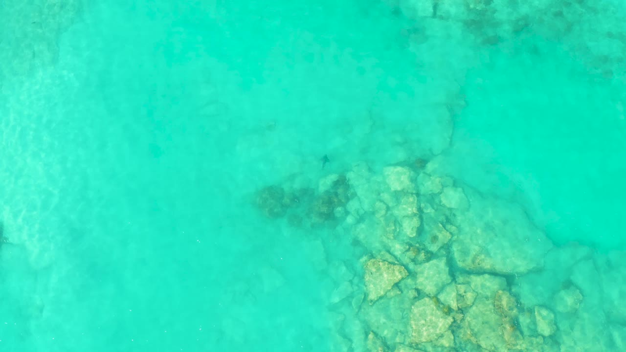 Transparent water above pale rocks