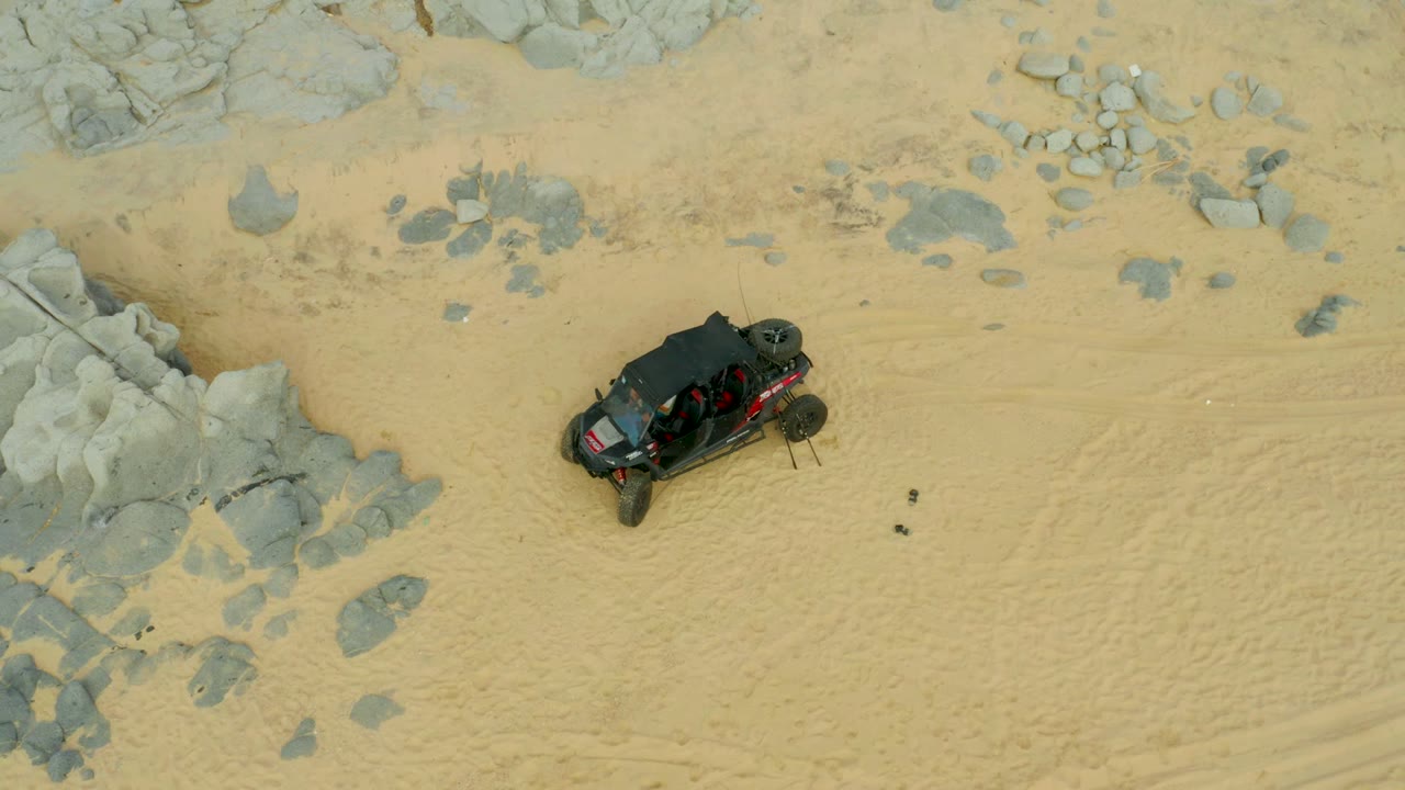 Overhead view of off-road vehicle crossing sandy rocky ground
