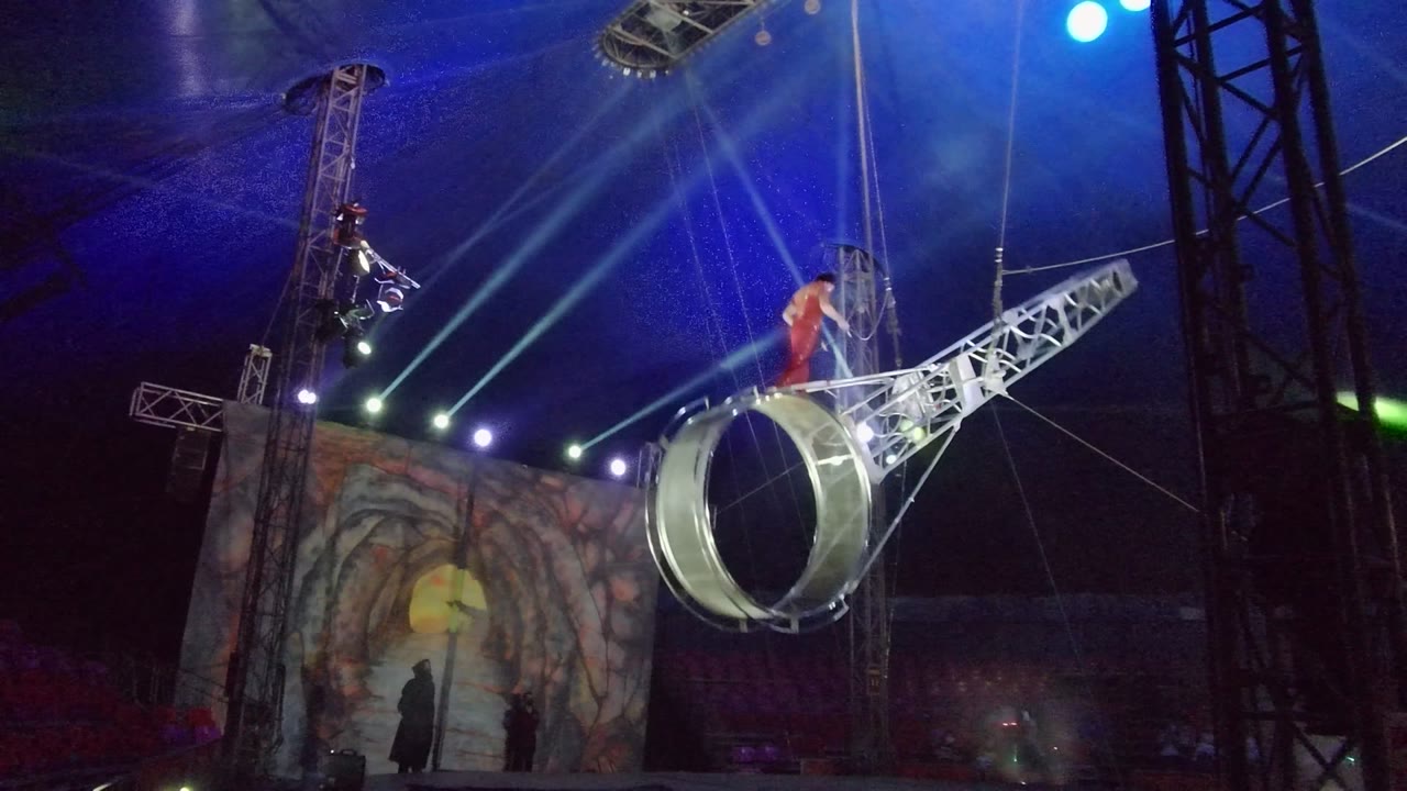 Ring apparatus tilted with performer in red near the top