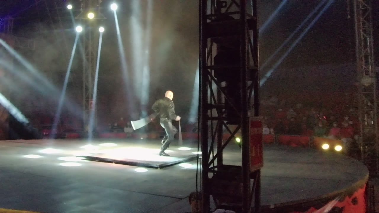 In San Jose Del Cabo, Mexico, the performer appears farther to the right of the stage while the flag trails and bright beams light the smoky air.