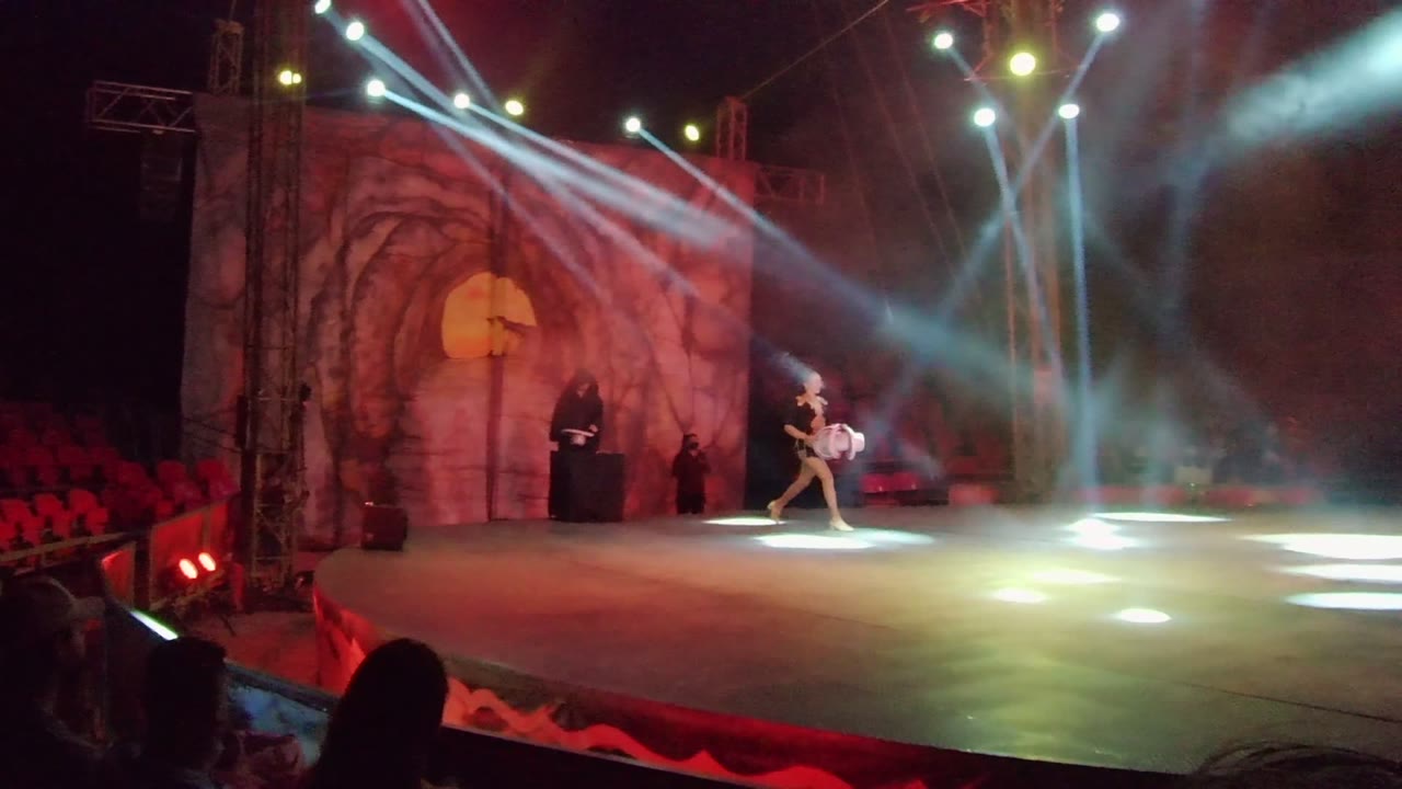 Dancer crossing stage under bright beams