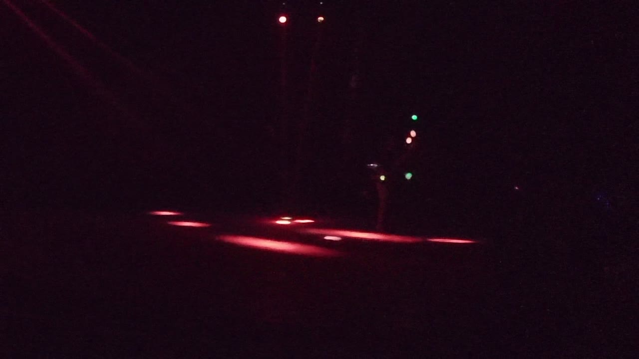 Red floor lights on a dark stage with small colored light points.