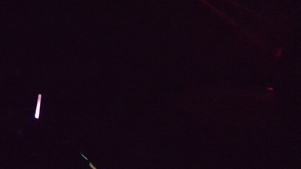 A very dark nighttime road view in San Jose Del Cabo with red vehicle light streaks low in the frame and no visible people.