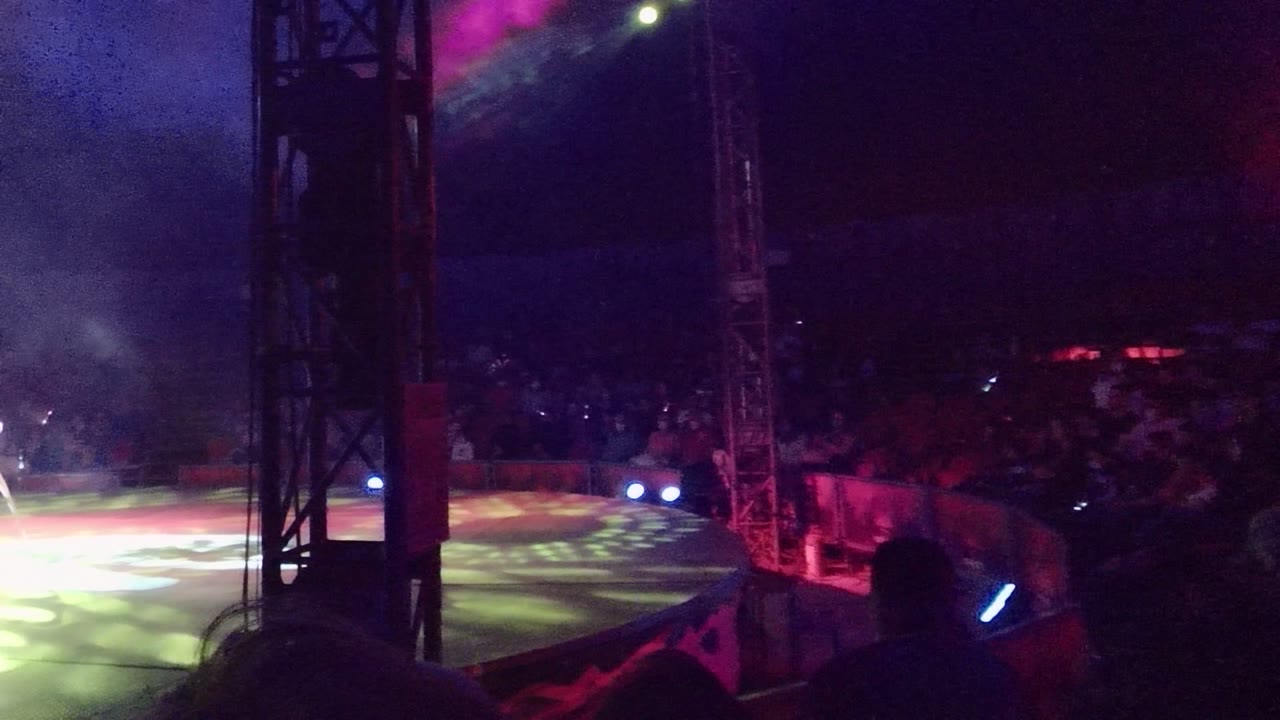 Stage area with colored spotlights and a white chair partly visible at right.