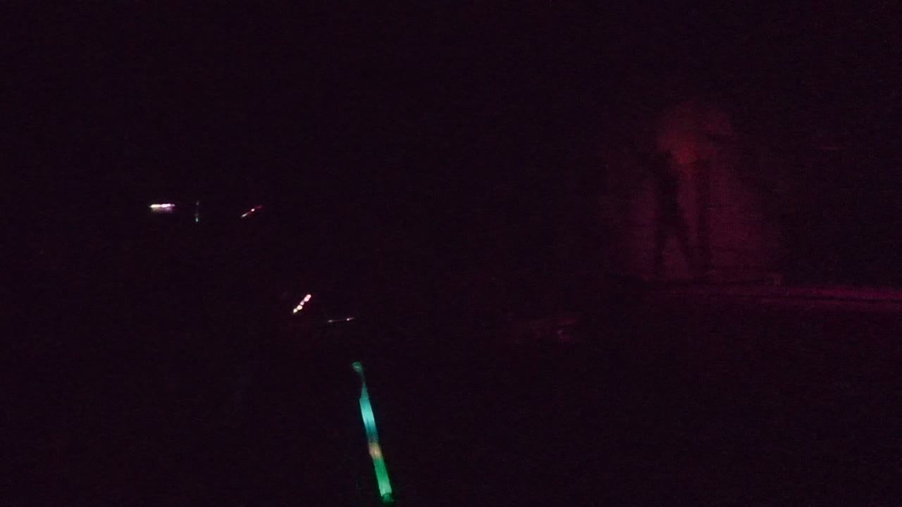 Dim stage with red backdrop and green foreground light.