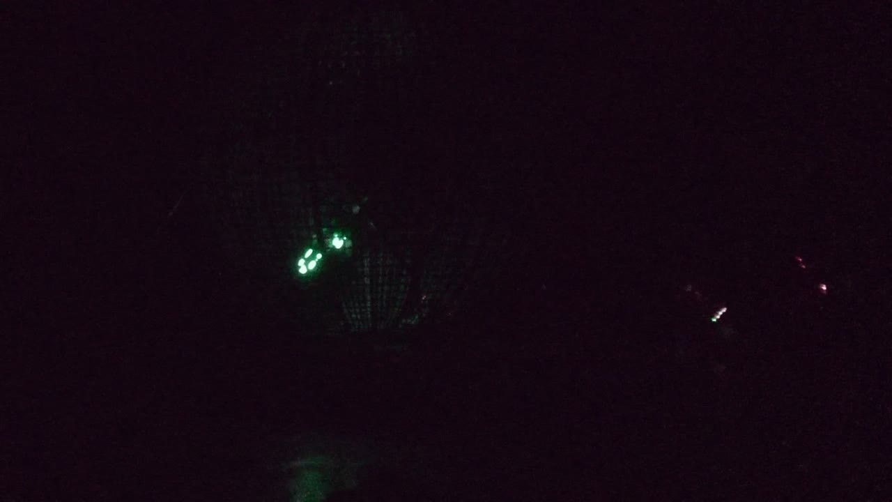 At 0:02 in San Jose Del Cabo, a compact green light cluster sits near the center while faint red accents remain in the surrounding darkness, with no visible people.
