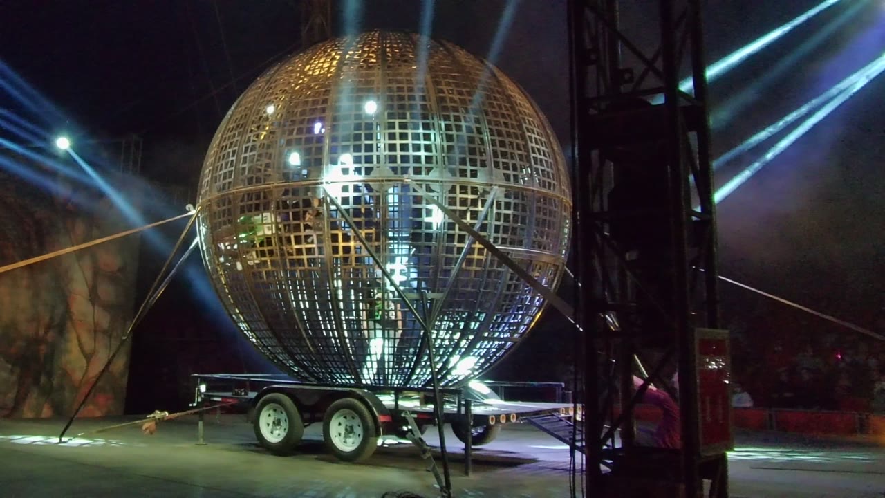 Illuminated spherical structure beside stage truss
