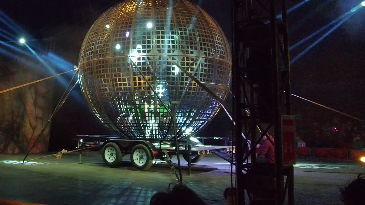 Reflective spherical structure on trailer with bright lights inside.