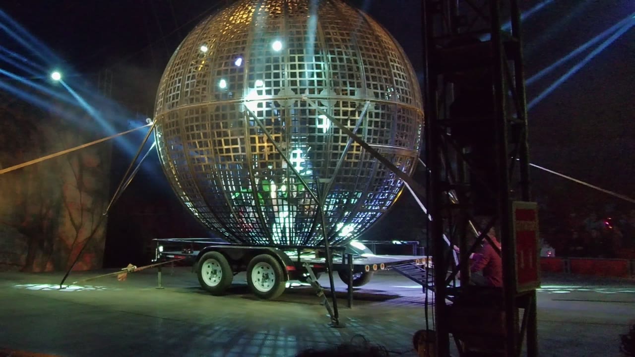 Lit spherical grid structure with spotlights behind it