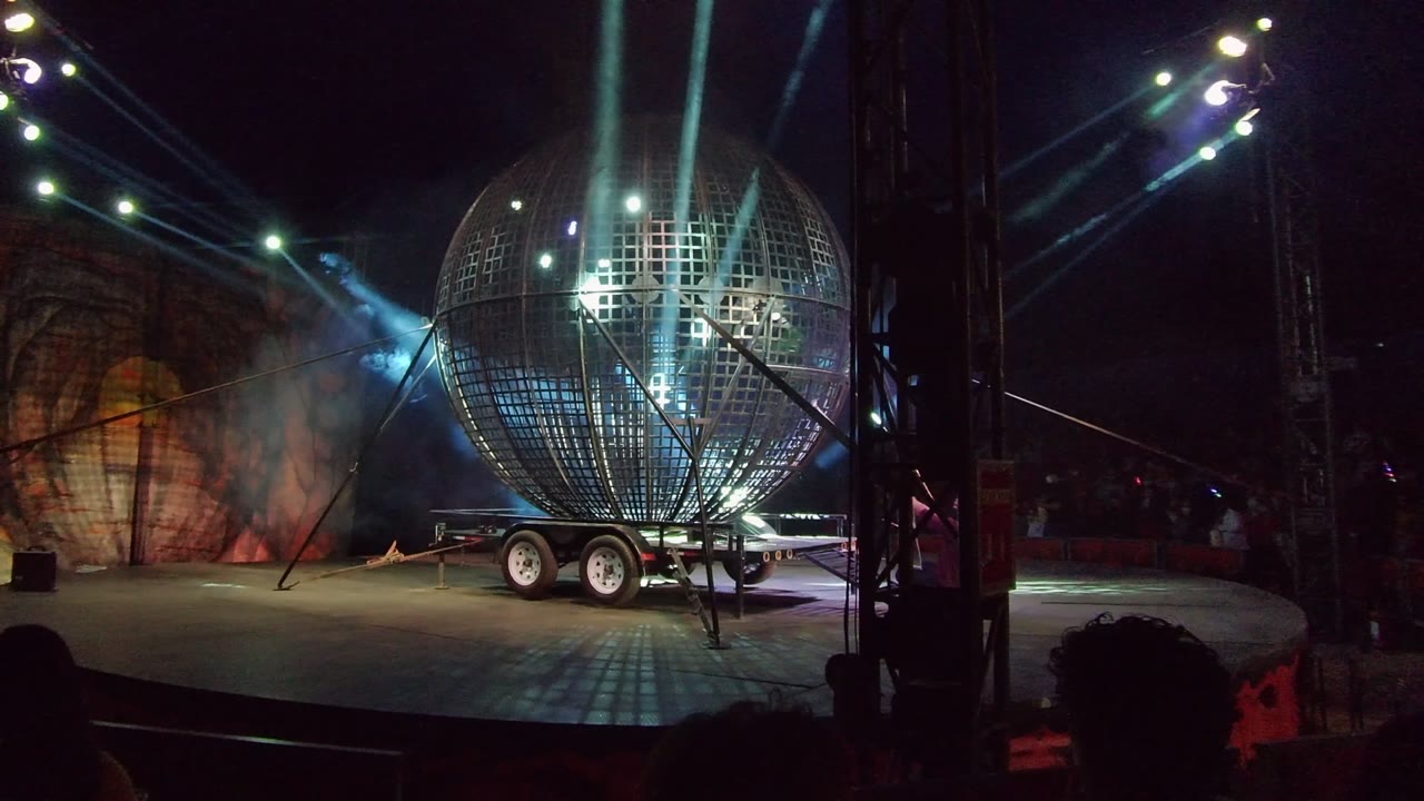 Spherical stage prop with bright beams crossing the stage.