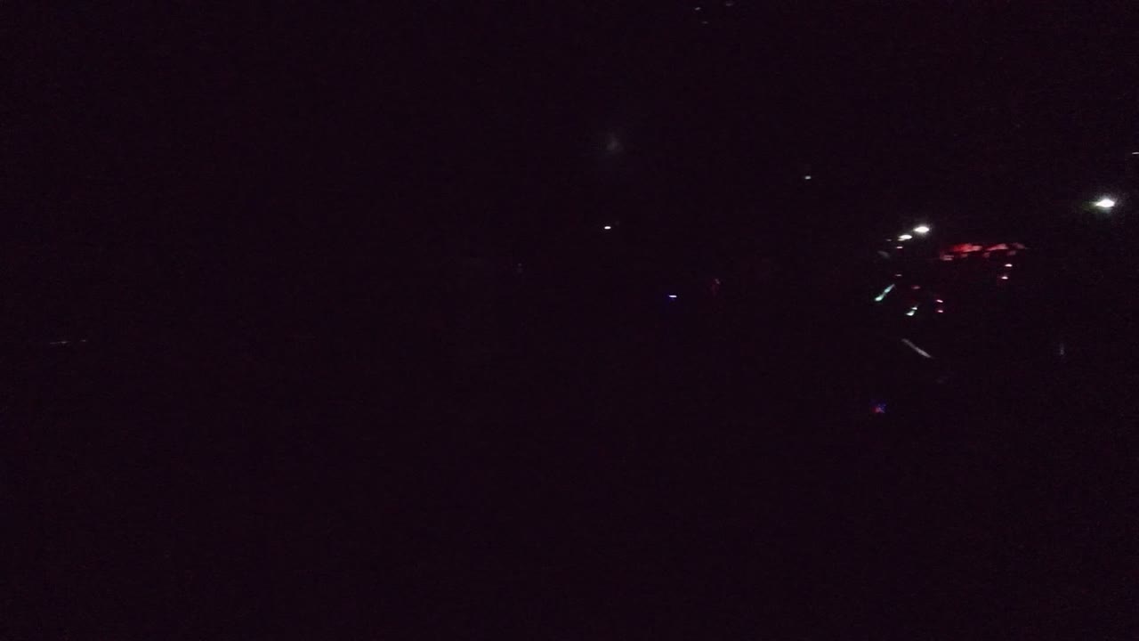 Very dark opening frame inside a San Jose del Cabo performance venue, with faint stage lights and seating mostly obscured by shadow.