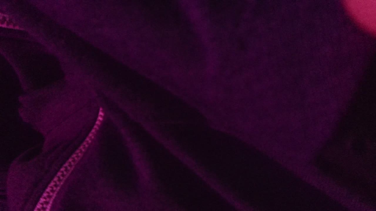 A San Jose Del Cabo 2022 close-up shows the purple jacket zipper and folds, with a small fingertip visible near the upper right edge.