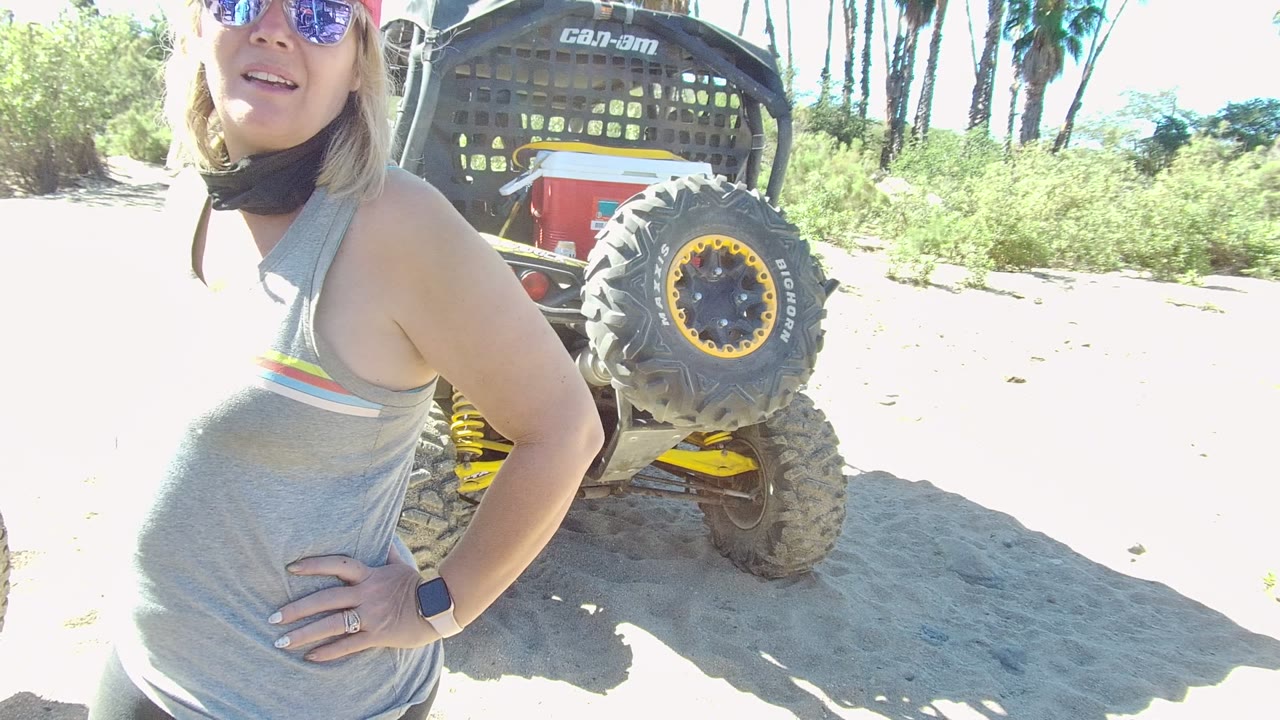Woman turns slightly toward the camera beside the utility vehicle.