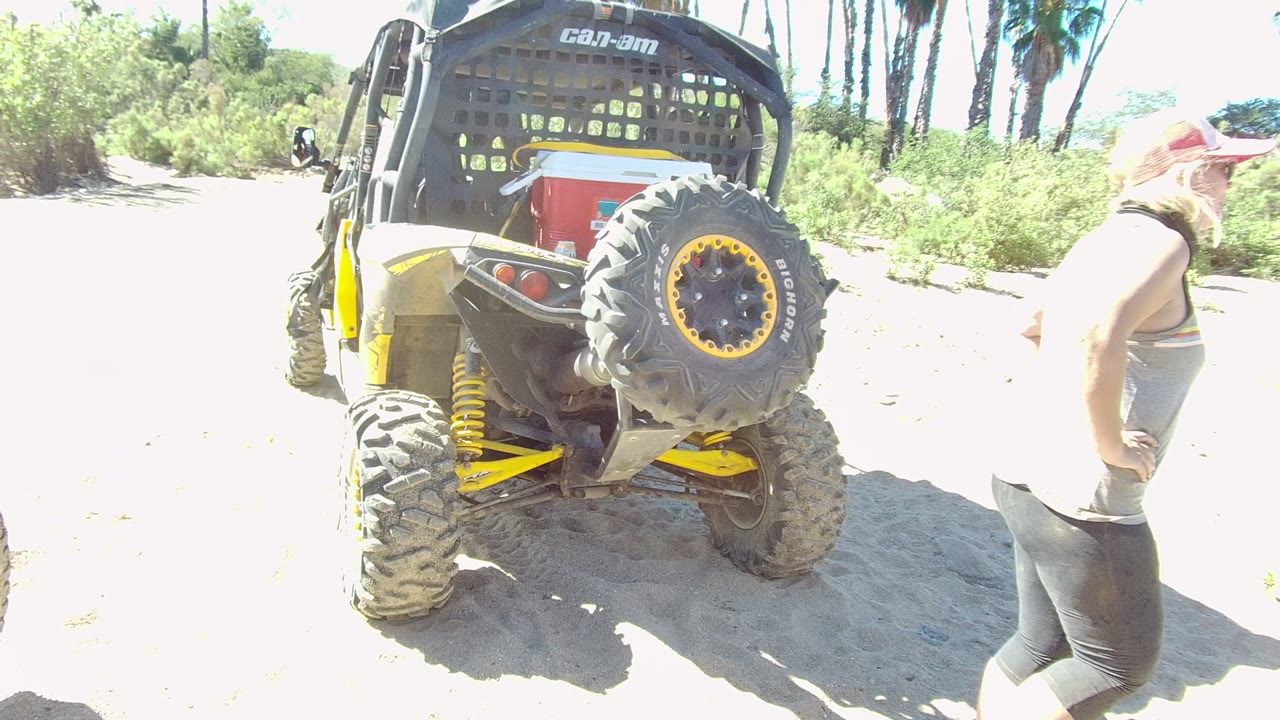 Off-road vehicle rear with a person walking along the right side of the frame.