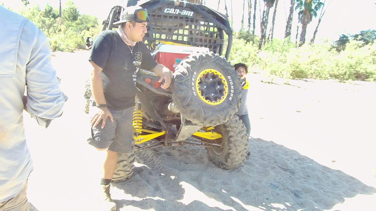 Child appears near the off-road vehicle as the man stands beside it.