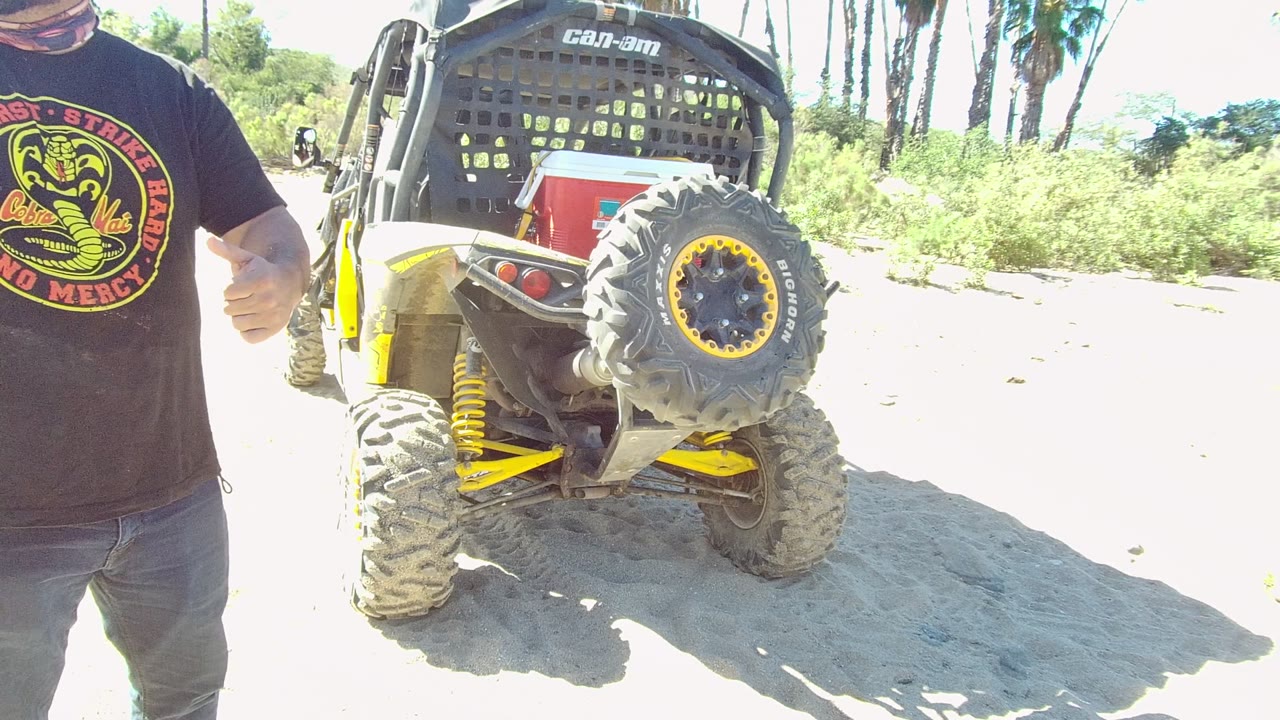 Man gives a thumbs-up beside a Can-Am off-road vehicle