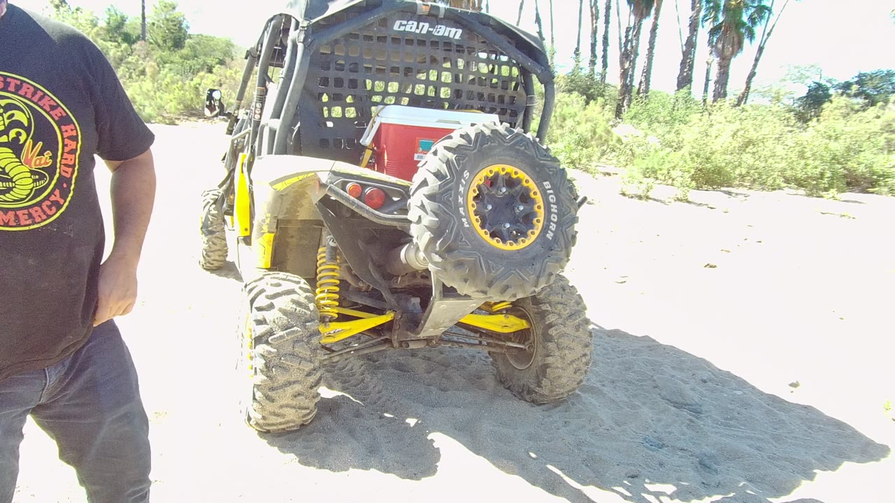 Cropped torso beside off-road vehicle on sandy terrain