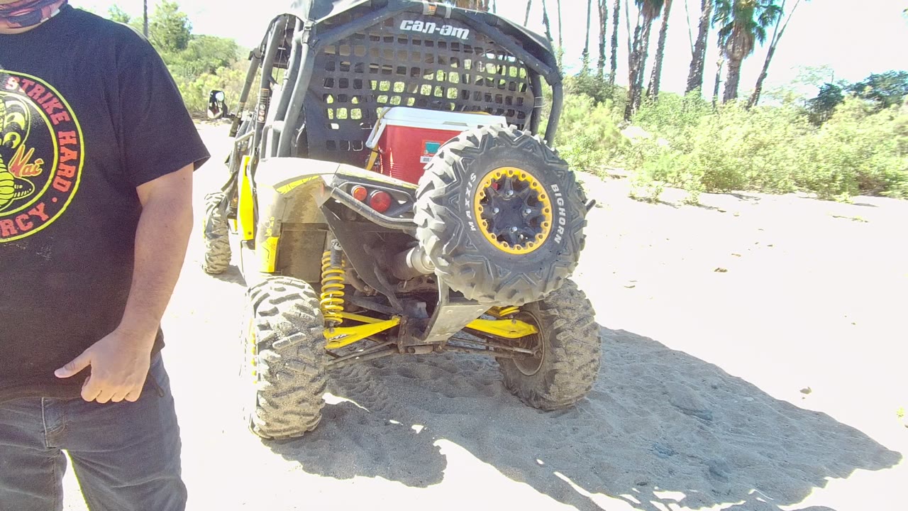 Rear of off-road vehicle with cropped man at the right edge.