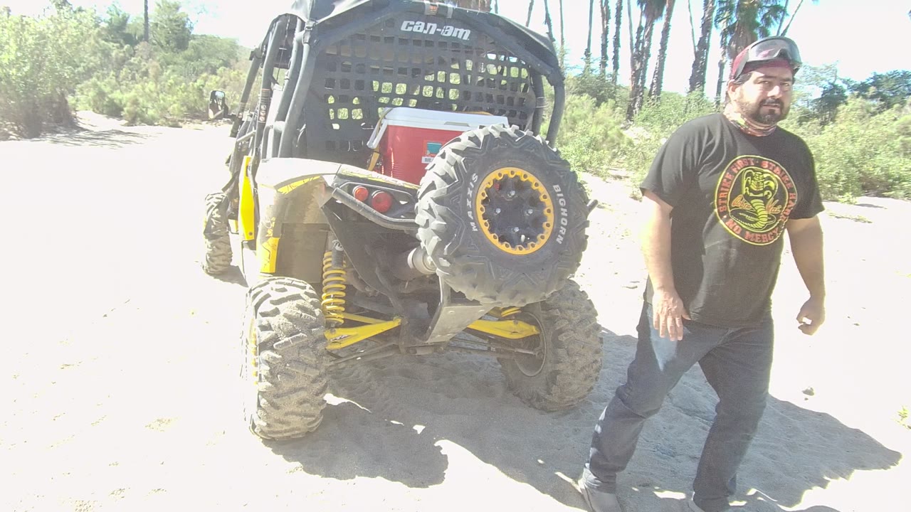 Man standing near the rear of an off-road vehicle.