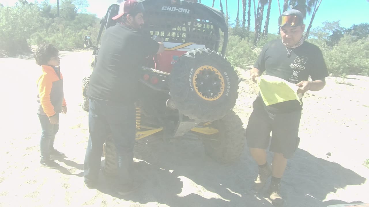 Man holding yellow towel near dune buggy