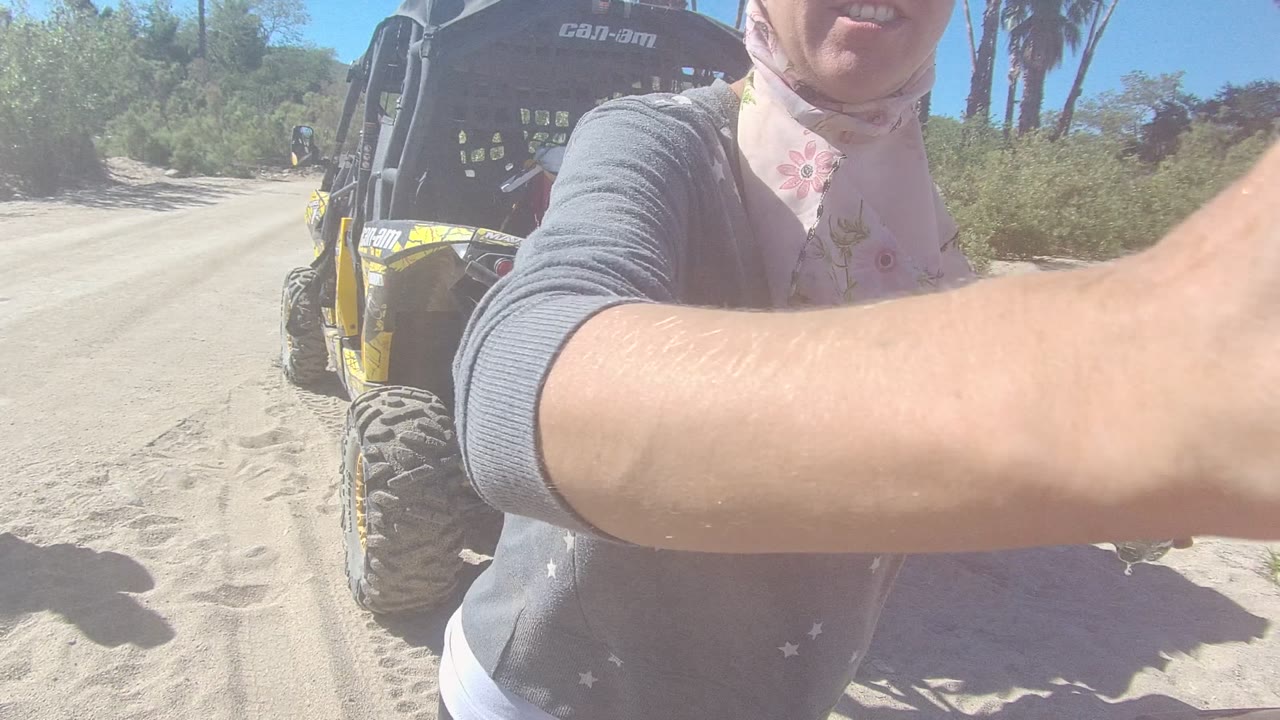 Person reaches an arm across the camera near a dune buggy.