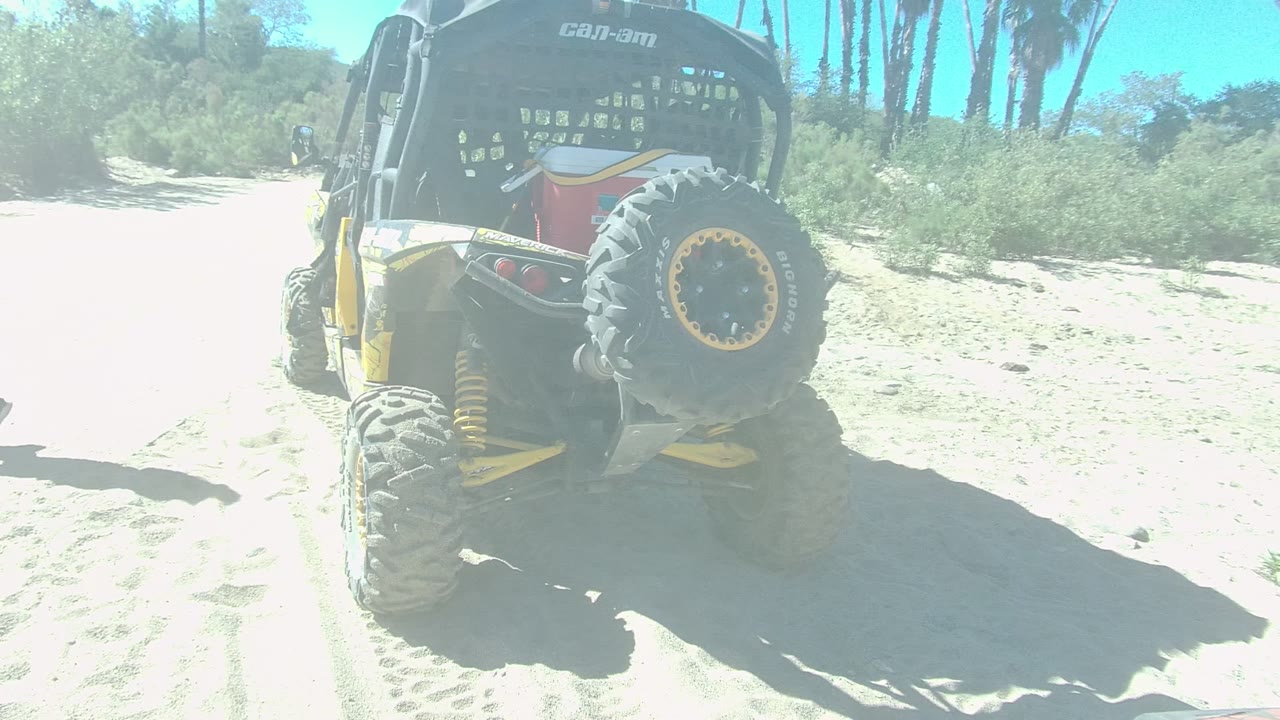 In Los Cabos, Baja California Sur, the dune buggy fills the left side of the frame while the walking person is nearly out of view at the right edge on the bright sand.