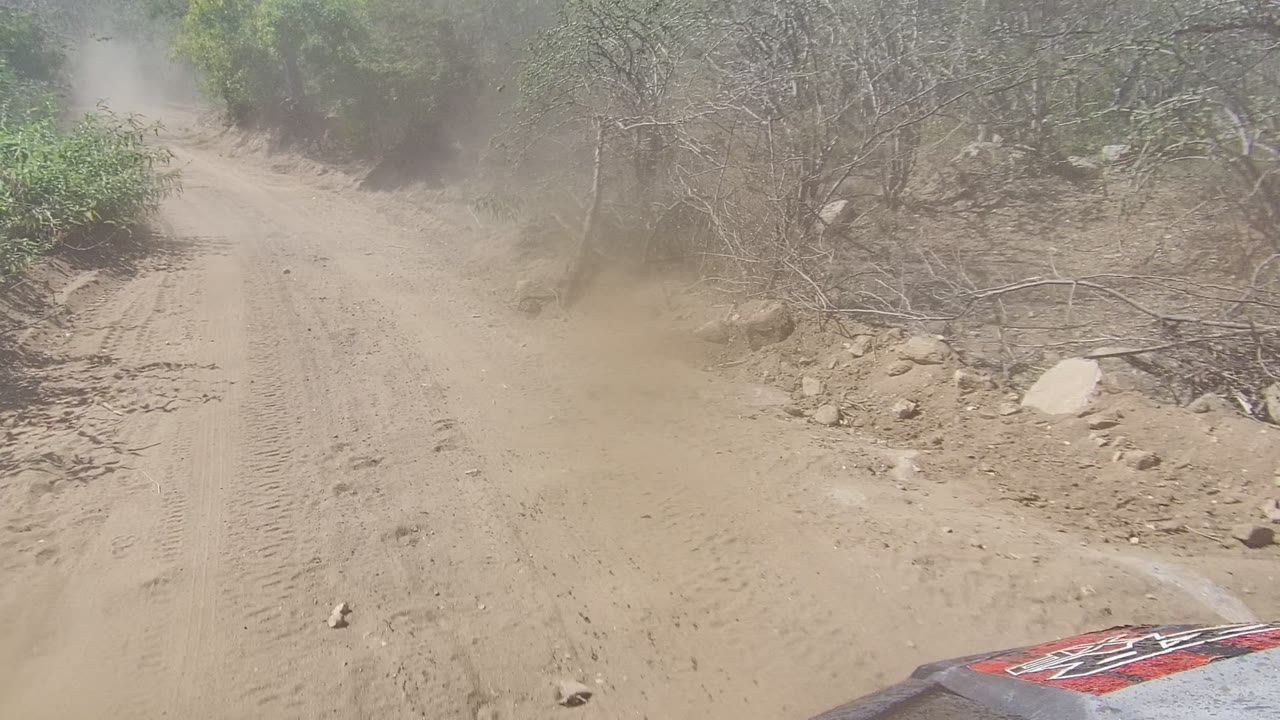 Sandy track ahead with dust hanging over the road