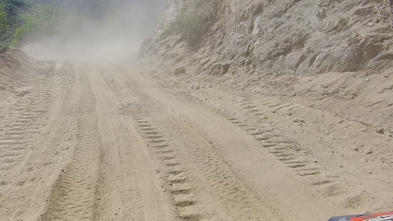 Rutted dirt road curving through dust and rocks