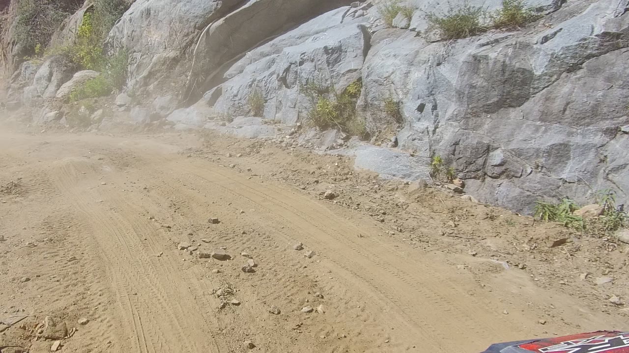 Curving sandy trail with rocks and shrubs