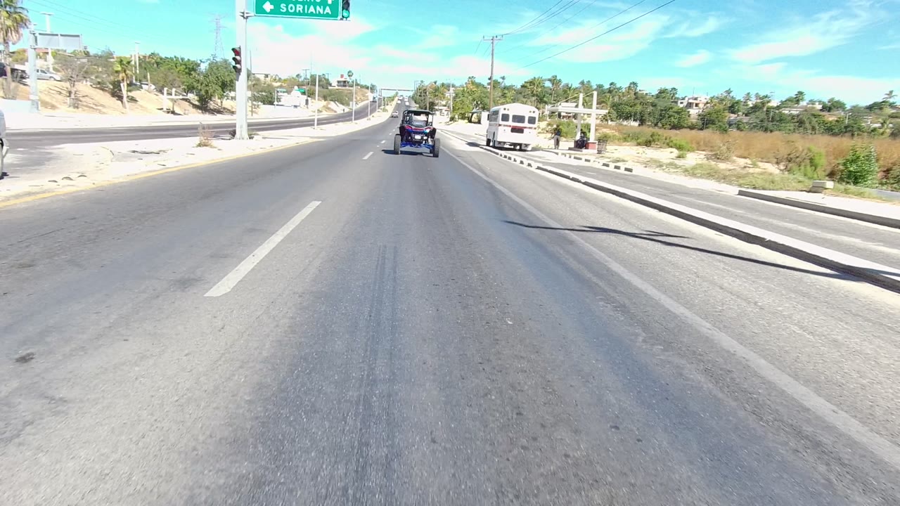 Open roadway with a blue carriage-like vehicle ahead.