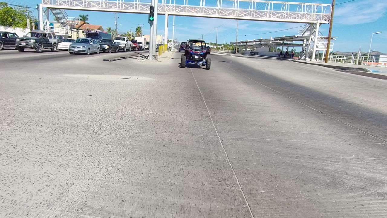 Vehicles waiting and moving through a bright urban intersection