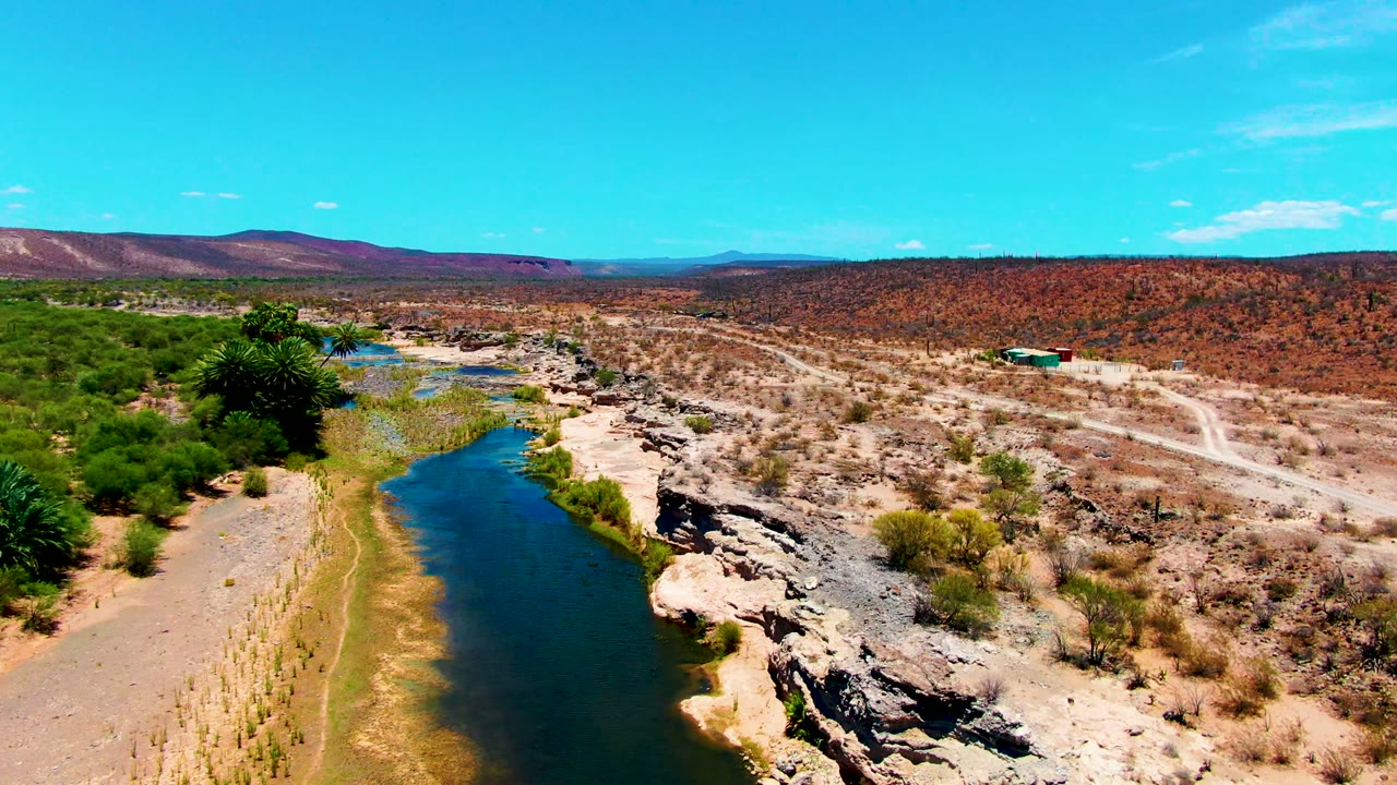 Aerial river view with scrubland and rocky banks.