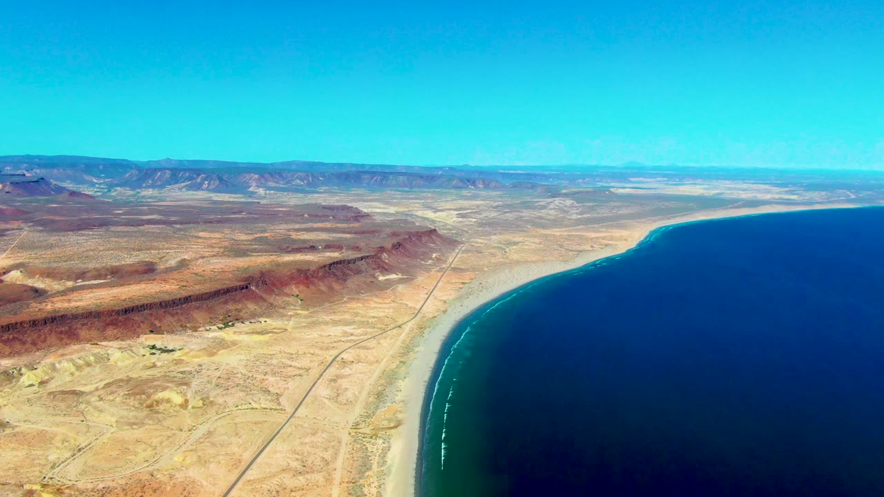 High aerial coastline with desert road beside the ocean