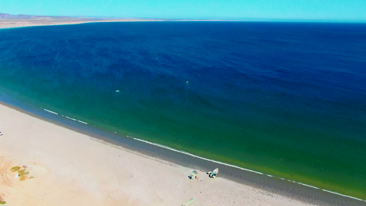 Blue ocean and sandy beach viewed from high above.