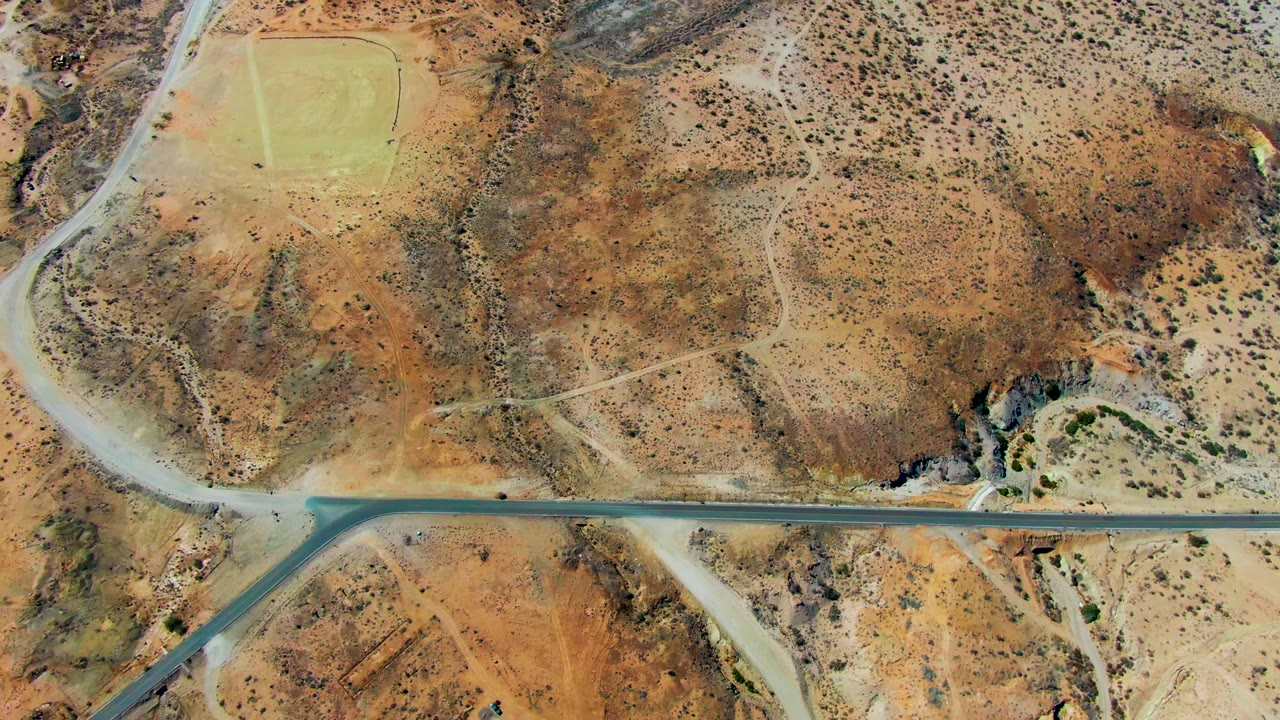 Overhead road crossing dry desert hills